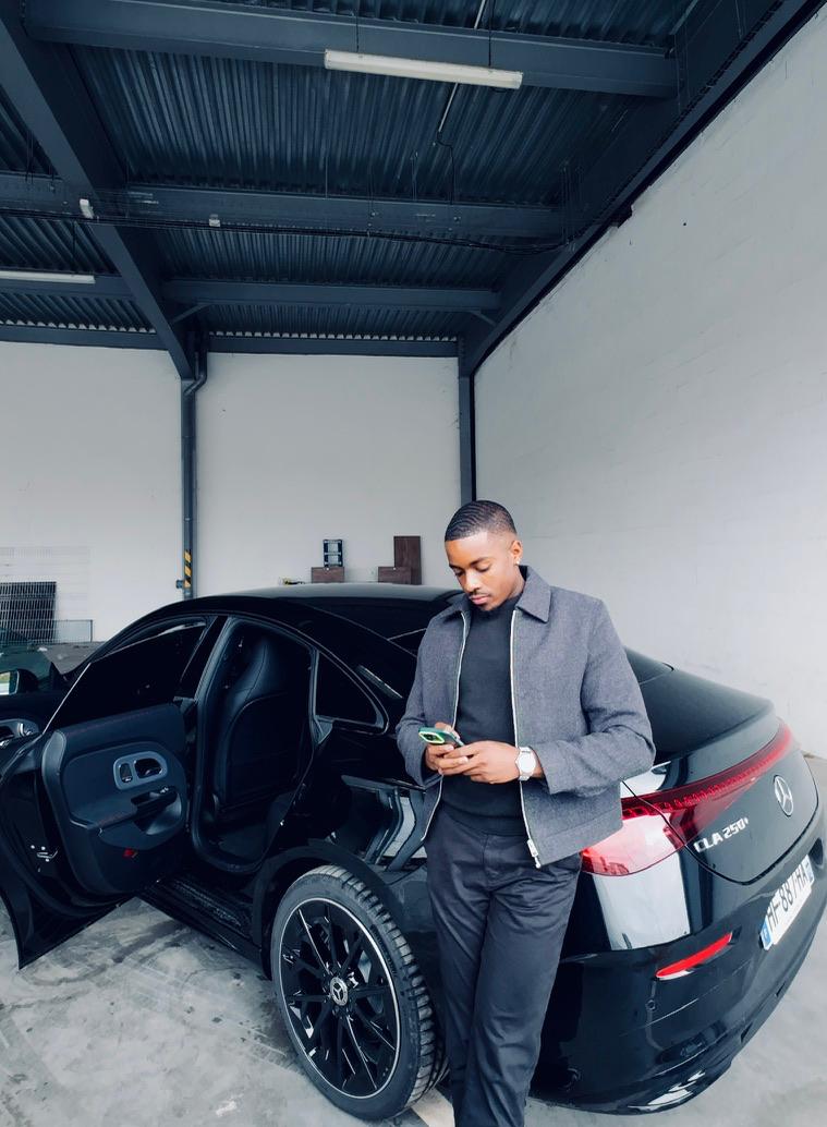 Brice Alexandre Bakabadio devant un véhicule noir pour BK.MADCARS